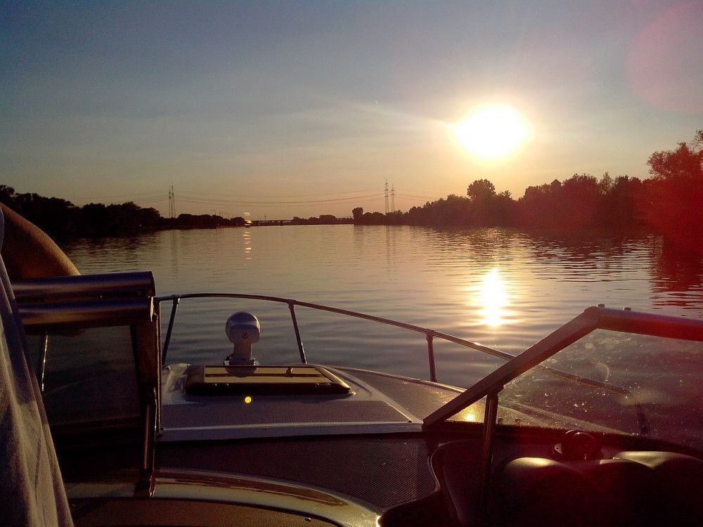 Sunset in calm waters from a boat with small outboard motor