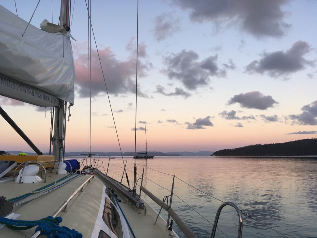 Sailboat motoring at dawn
