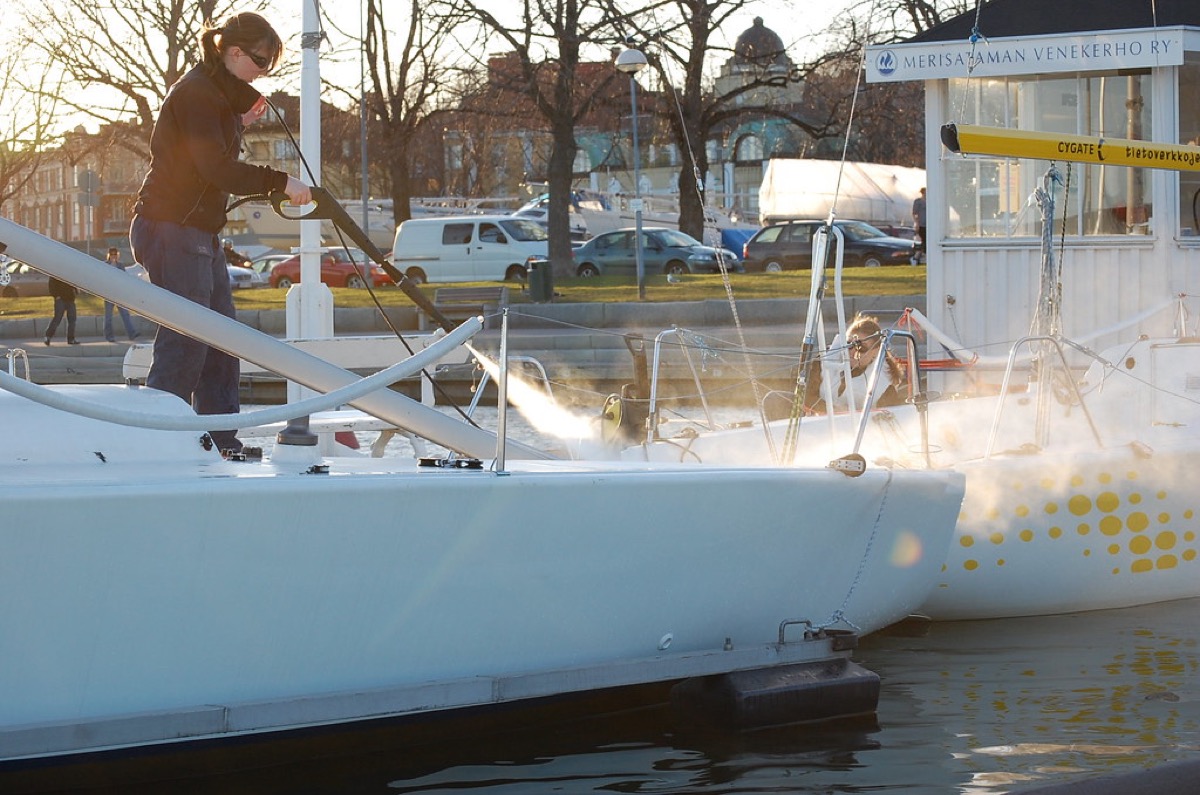 Woman cleaning boat with hose