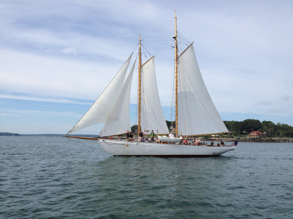 White schooner with white sails and light wooden masts