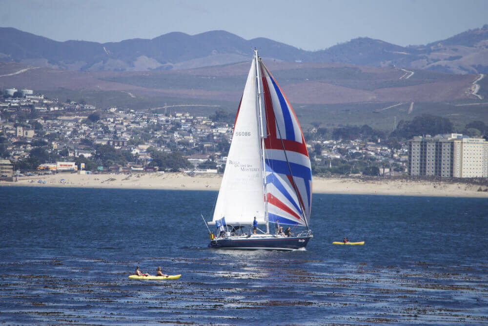 Large sailing yacht sailing coastal water using a true spinnaker