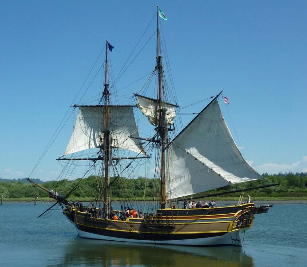 Replica of brigatine on lake with lots of rigging and brown, green, red, and gold paint