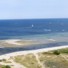 Birdseye view of beach and coastline with lots of small sailboats