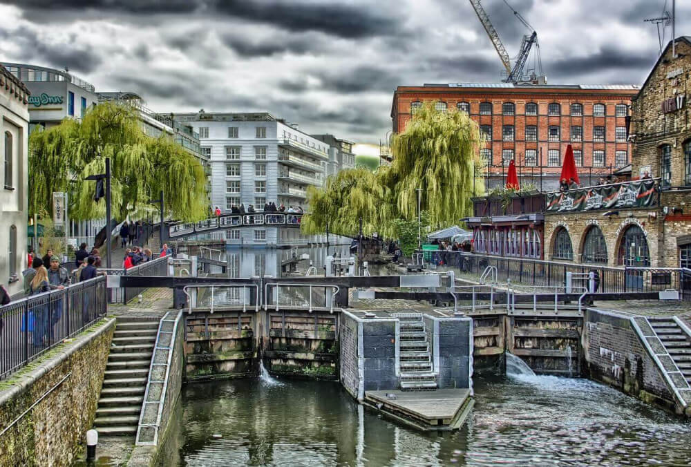 Canal lock in middle of London, UK, with grey sky and orange building