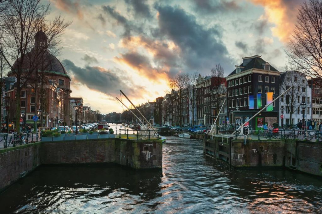 Canal lock in city of Amsterdam with old buildings