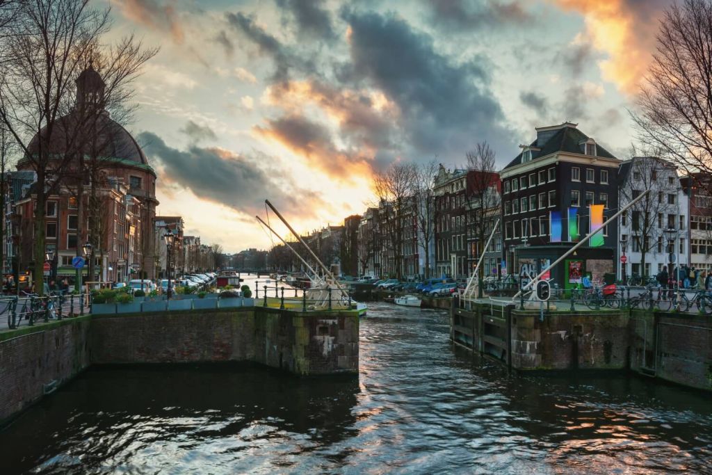 Canal lock in city of Amsterdam with old buildings