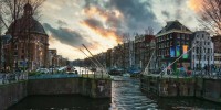 Canal lock in city of Amsterdam with old buildings