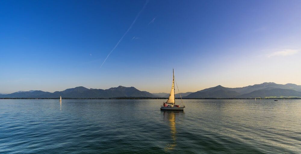 Smooth water sailboat panorama with dusk setting in