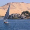 Sailboat in coastal waters with desert hill in the background