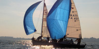 Italian sailboats with blue sails competing in sunny weather