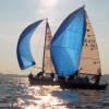 Italian sailboats with blue sails competing in sunny weather