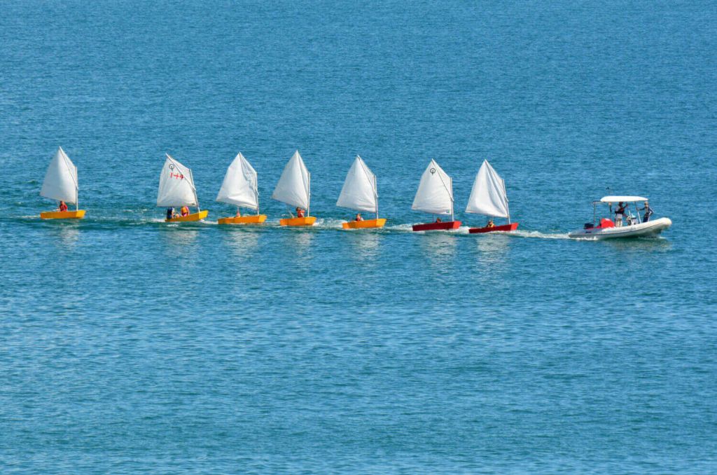 Sail instructor tows seven dinghies with a powerboat