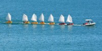 Sail instructor tows seven dinghies with a powerboat