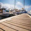 Wooden boardwalk in marina with boats tied up on either side