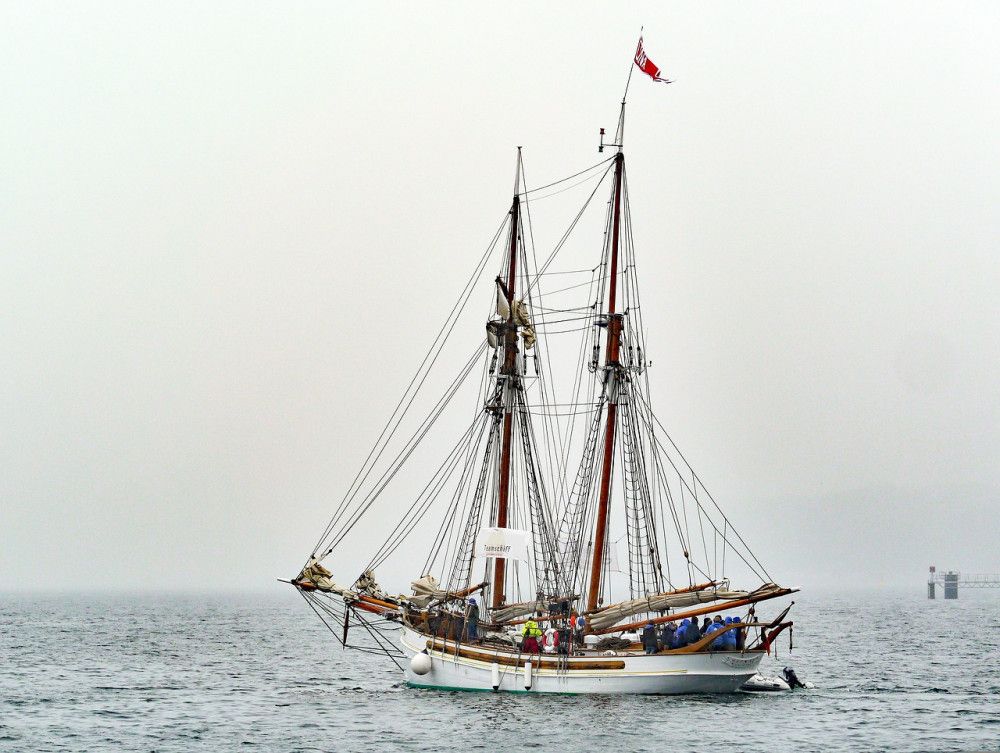 Two-masted, classical sailboat sailing under power