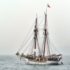 Two-masted, classical sailboat sailing under power
