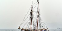 Two-masted, classical sailboat sailing under power