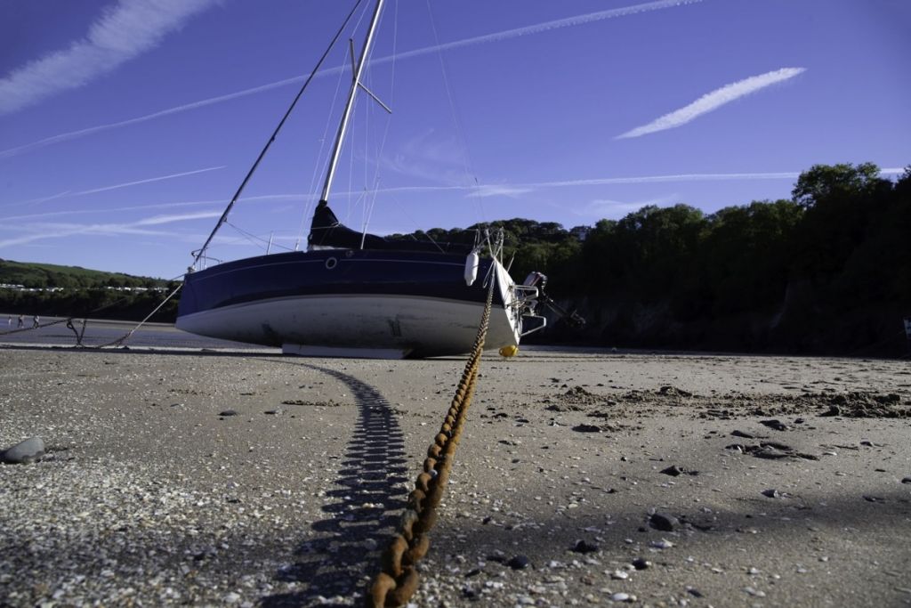 Sailboat with anchor chain in sand