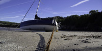 Sailboat with anchor chain in sand