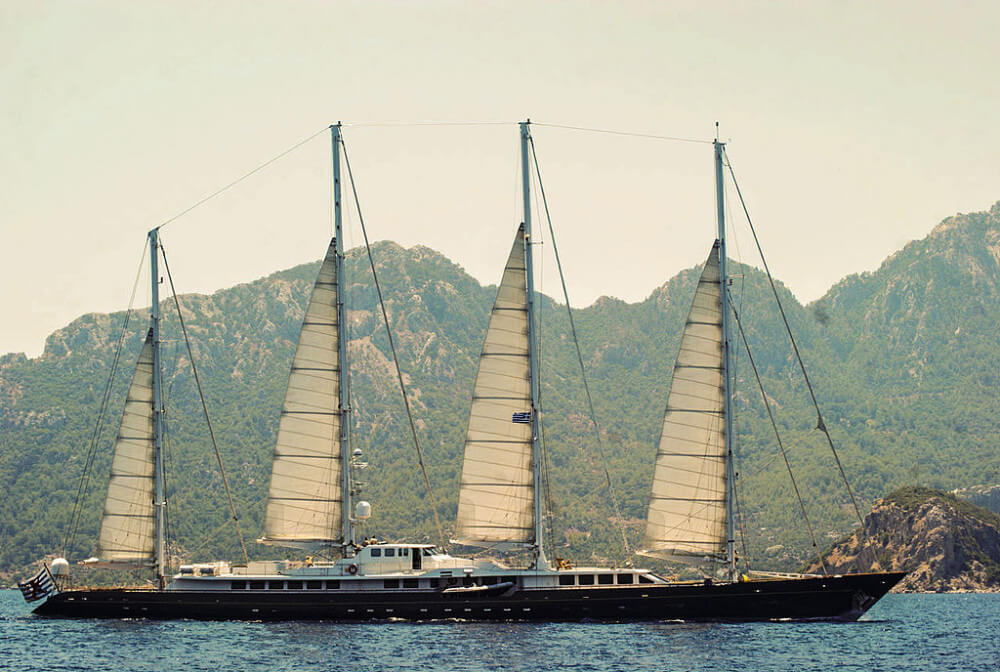 Phocea large four masted yacht on backdrop of mountains