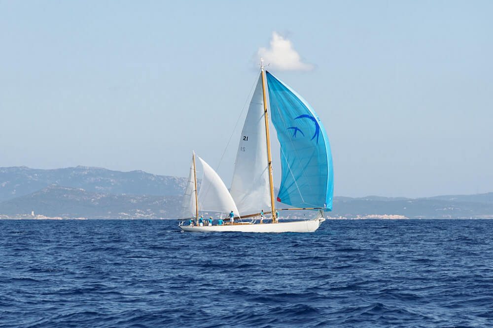 White yawl with two masts and blue spinnaker