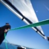Man on sailboat holding green line