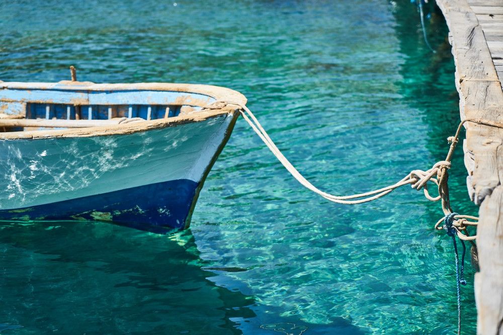 Small boat in blue water of marina