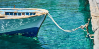 Small boat in blue water of marina