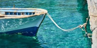 Small boat in blue water of marina