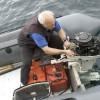 Old man works on boat engine