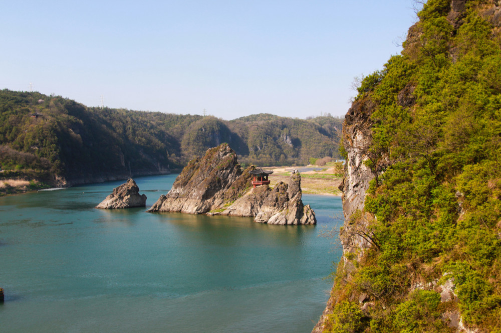 Small tea house on cliff in bay in blue ocean