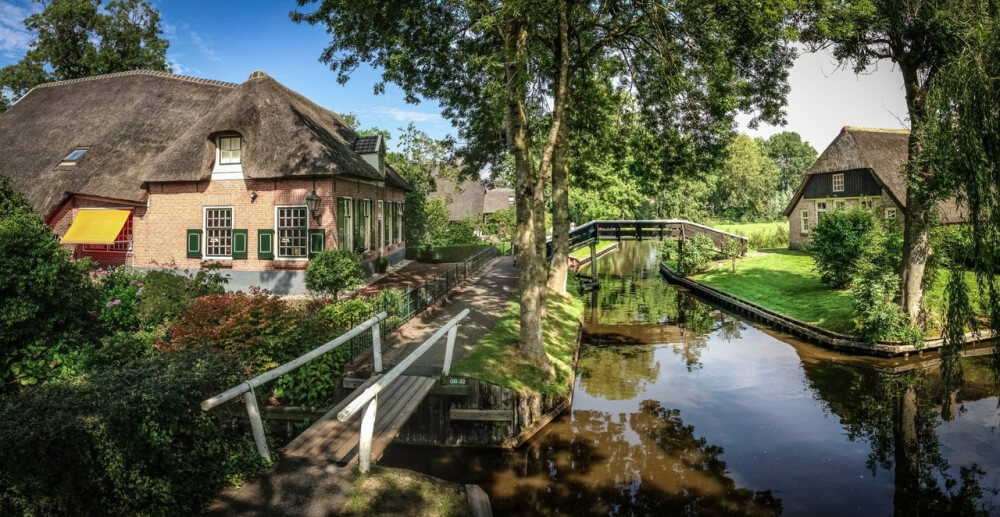 Beautiful farm near small canal with small wooden bridges, in Giethoorn, Holland.