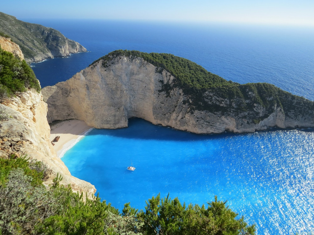 Beach with a shipwreck in a blue sea